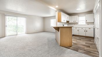 A spacious kitchen with white cabinets and a wooden island.